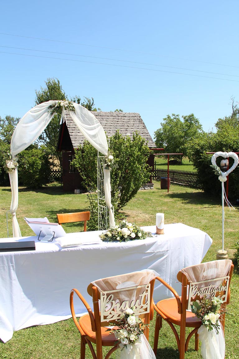 Outdoor Trauungsplatz mit festlich geschmücktem Traubogen und Brautpaar-Stühlen bei FEIEREI, romantische wedding location in Oberösterreich.