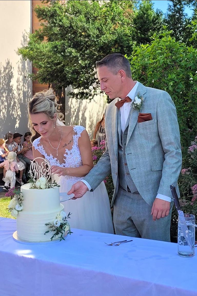 Hochzeitspaar beim Anschneiden der Torte im Garten von FEIEREI, romantische wedding location in Oberösterreich für unvergessliche Feiermomente.