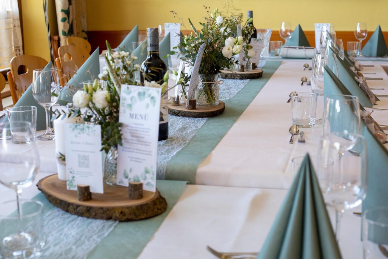 Festlich dekorierte Hochzeitstafel mit Blumenschmuck und Menükarte bei FEIEREI, stilvolle wedding location in Oberösterreich.