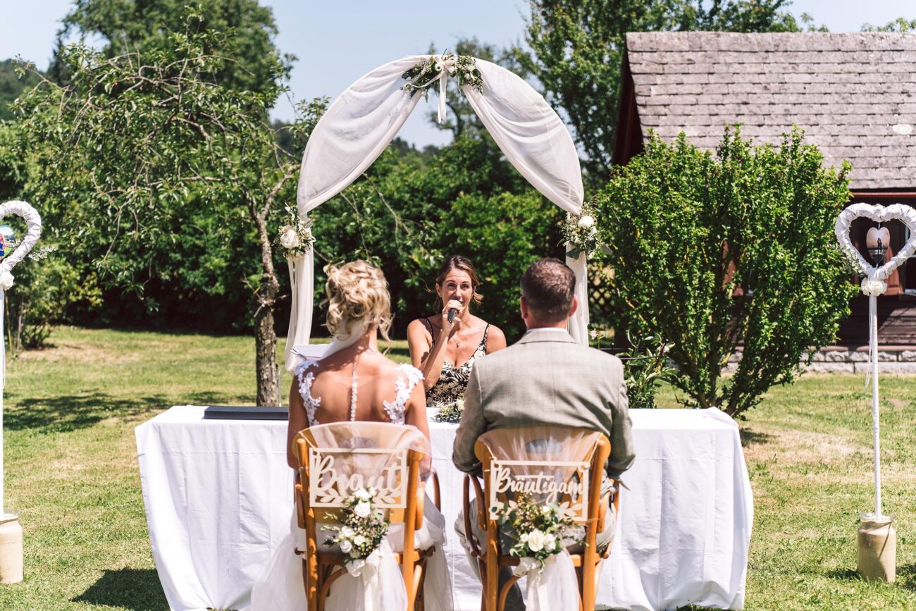 Braut und Bräutigam während der Trauungszeremonie im Garten der FEIEREI, romantische wedding location in Oberösterreich für Hochzeiten im Freien.