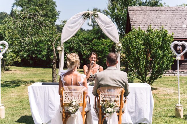 Braut und Bräutigam während der Trauungszeremonie im Garten der FEIEREI, romantische wedding location in Oberösterreich für Hochzeiten im Freien.