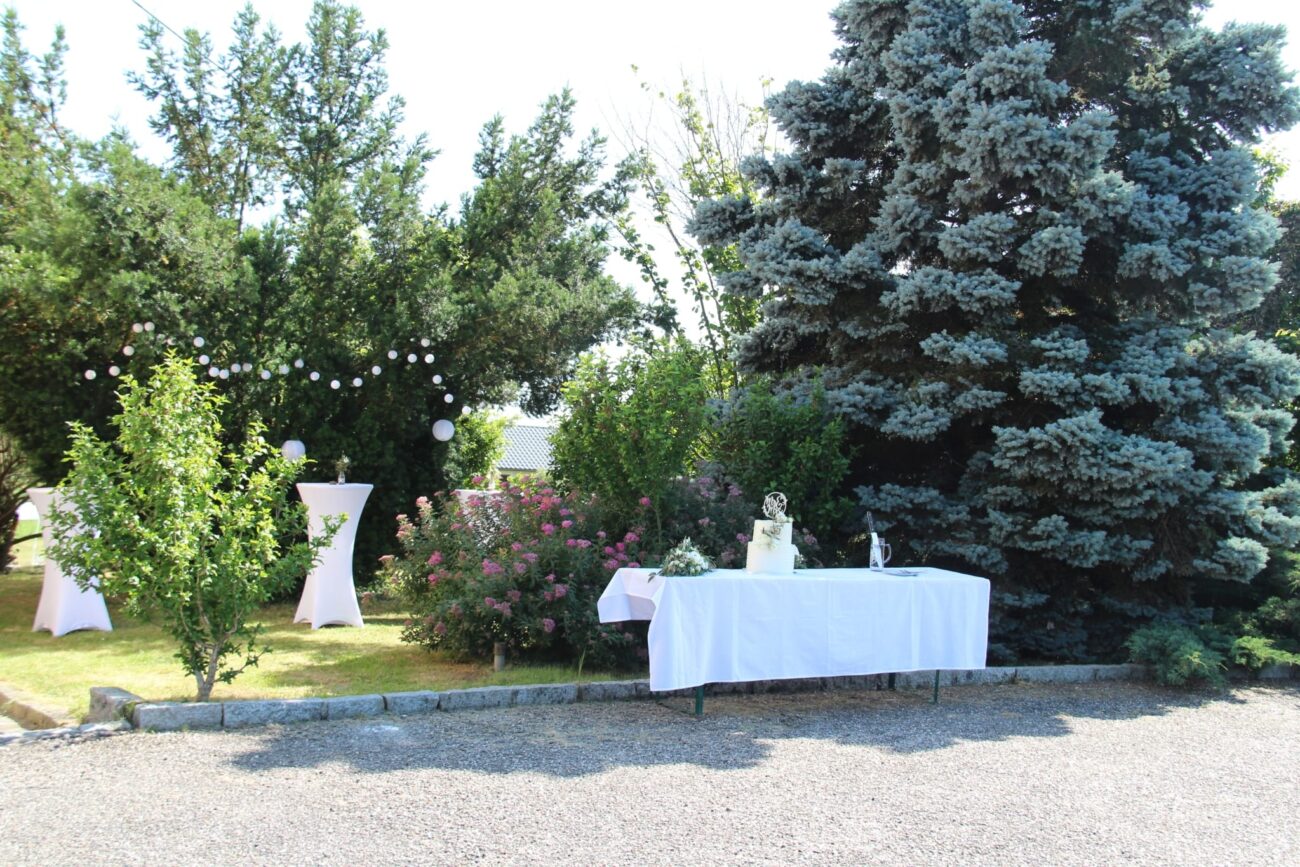 Außenbereich der FEIEREI mit festlich gedecktem Tisch und Hochzeitstorte, idyllische wedding location in Oberösterreich im Grünen.